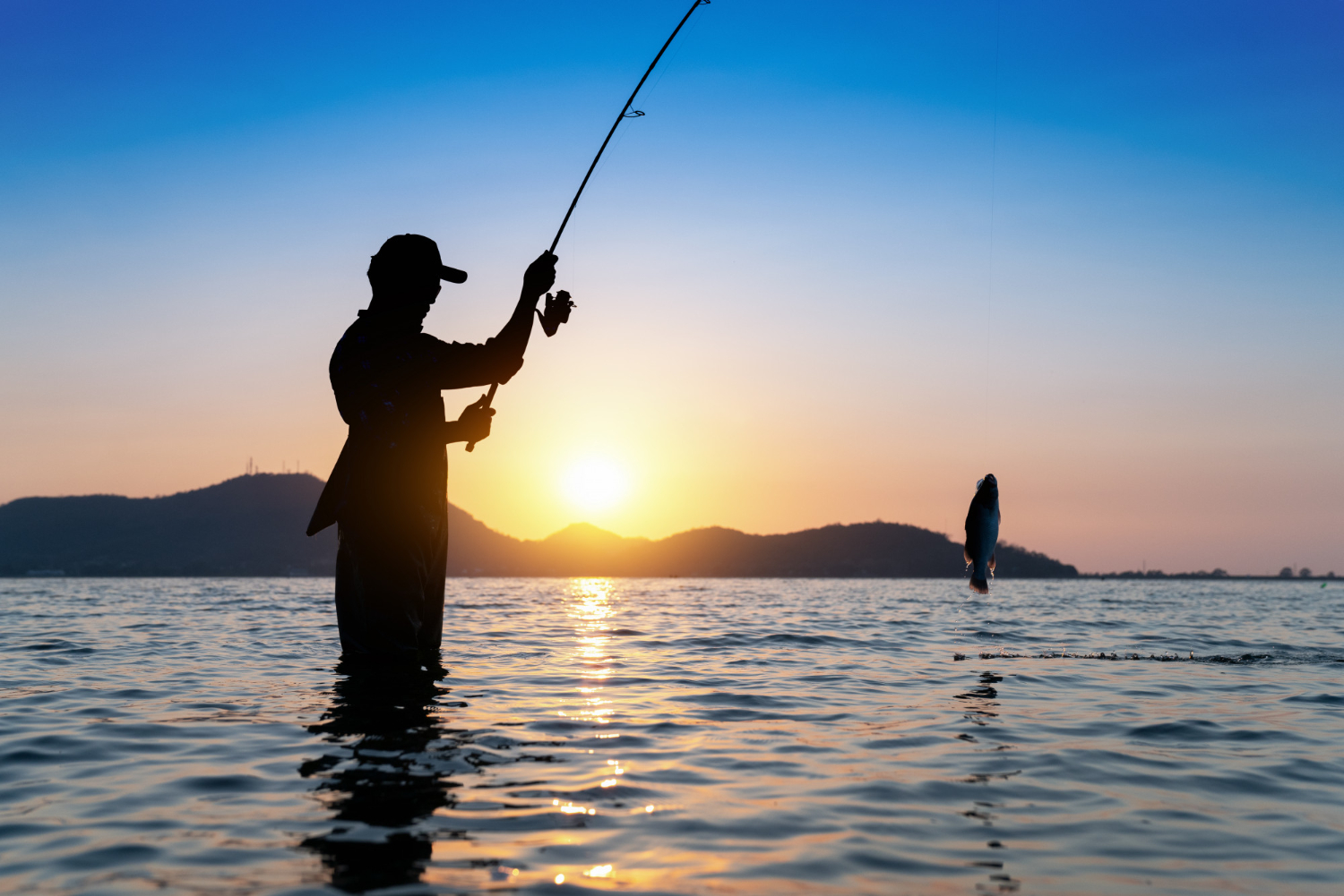 Pesca en la playa con mar azul y sol brillante en el cielo azul y dos cañas  de pescar